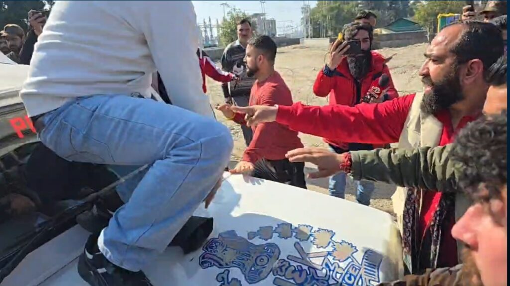 Jammu protest National Emblem disrespect Protester standing on Jammu and Kashmir Police Gypsy bonnet bearing the National Emblem during NLU protest near Tawi Bridge